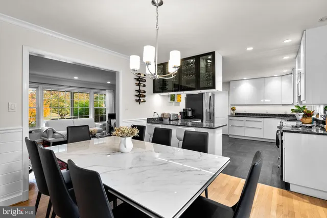 a kitchen with a dining table chairs and refrigerator