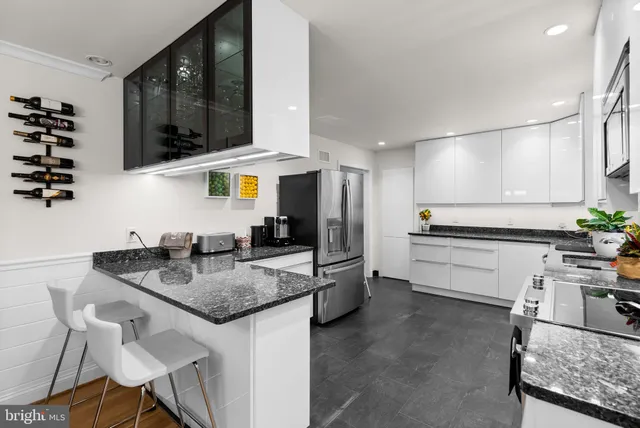 a kitchen with stainless steel appliances granite countertop a sink and a refrigerator