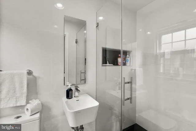 a view of a kitchen with kitchen island a sink a counter top space and stainless steel appliances
