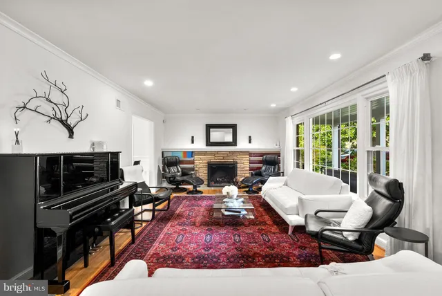 a living room with fireplace furniture and a large window