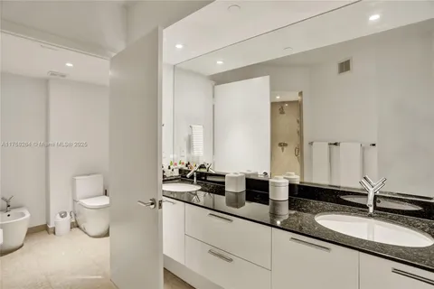 a bathroom with a double vanity sink toilet and a mirror