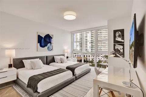 a bedroom with furniture and a large window