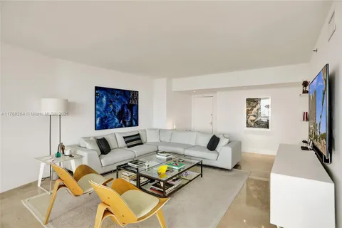 a living room with furniture a flat screen tv and a table