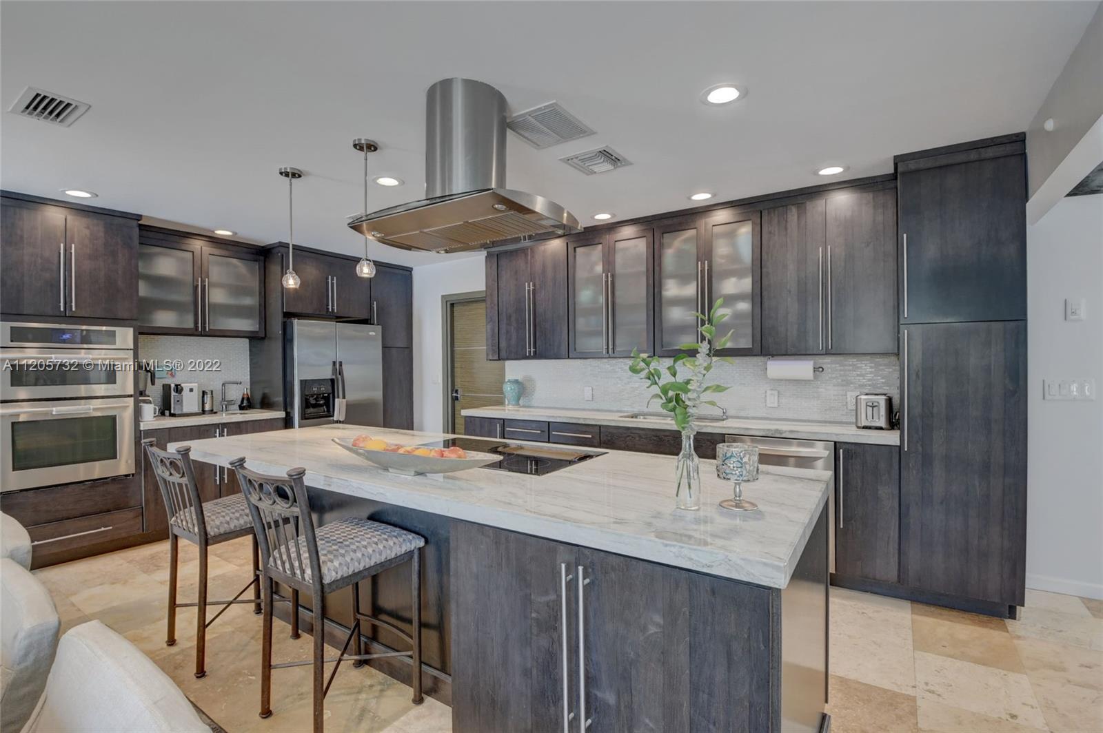 1291 Southwest 4th Court Boca Raton, FL 33432 - Photo 12 of 54 a kitchen with stainless steel appliances kitchen island granite countertop a sink and cabinets