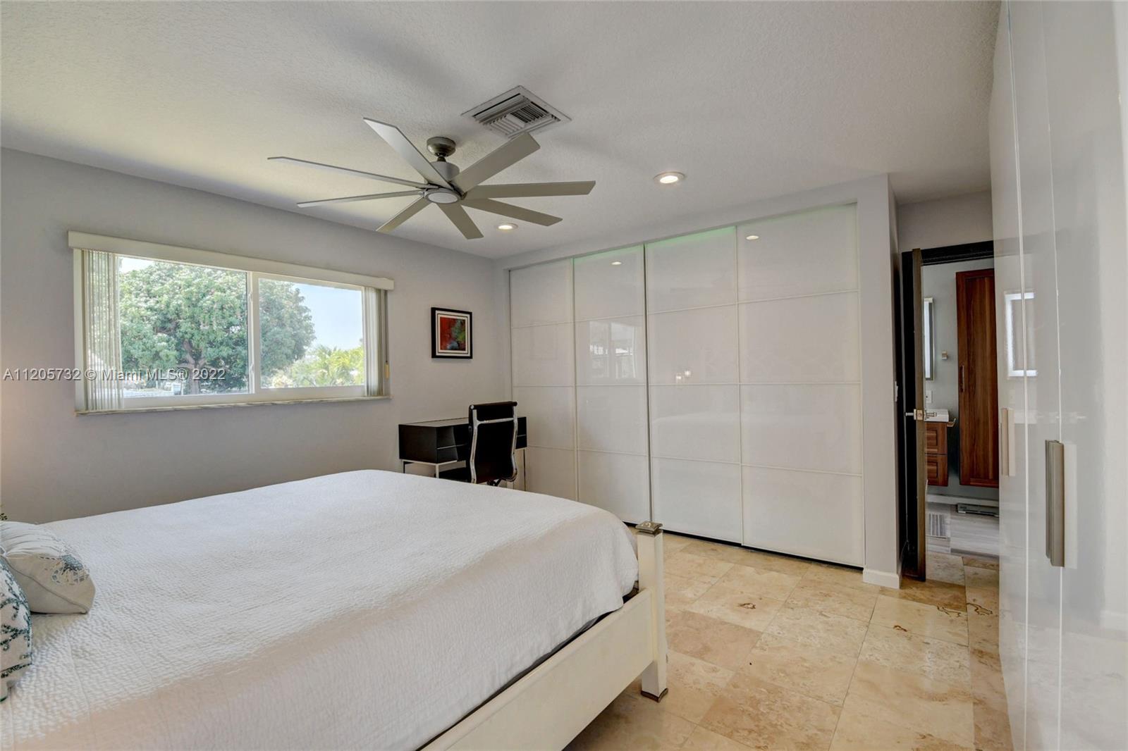 1291 Southwest 4th Court Boca Raton, FL 33432 - Photo 19 of 54 a bedroom with a large bed and a chandelier