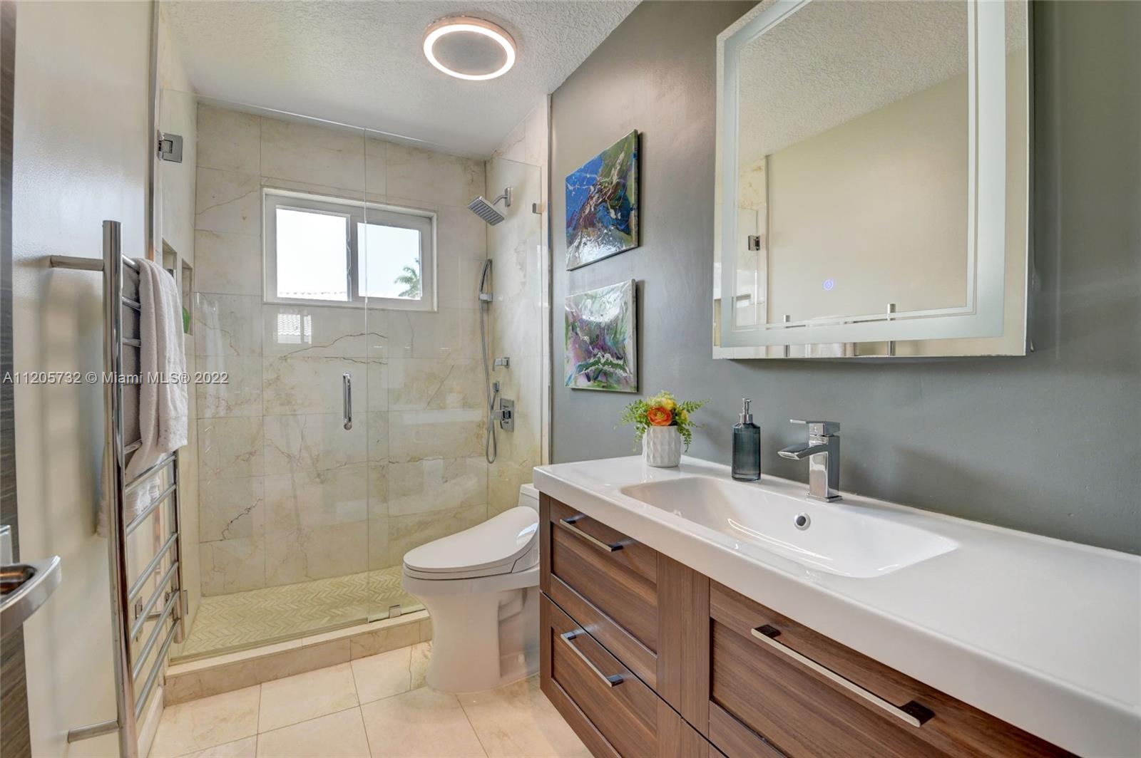1291 Southwest 4th Court Boca Raton, FL 33432 - Photo 25 of 54 a bathroom with a sink a toilet and shower