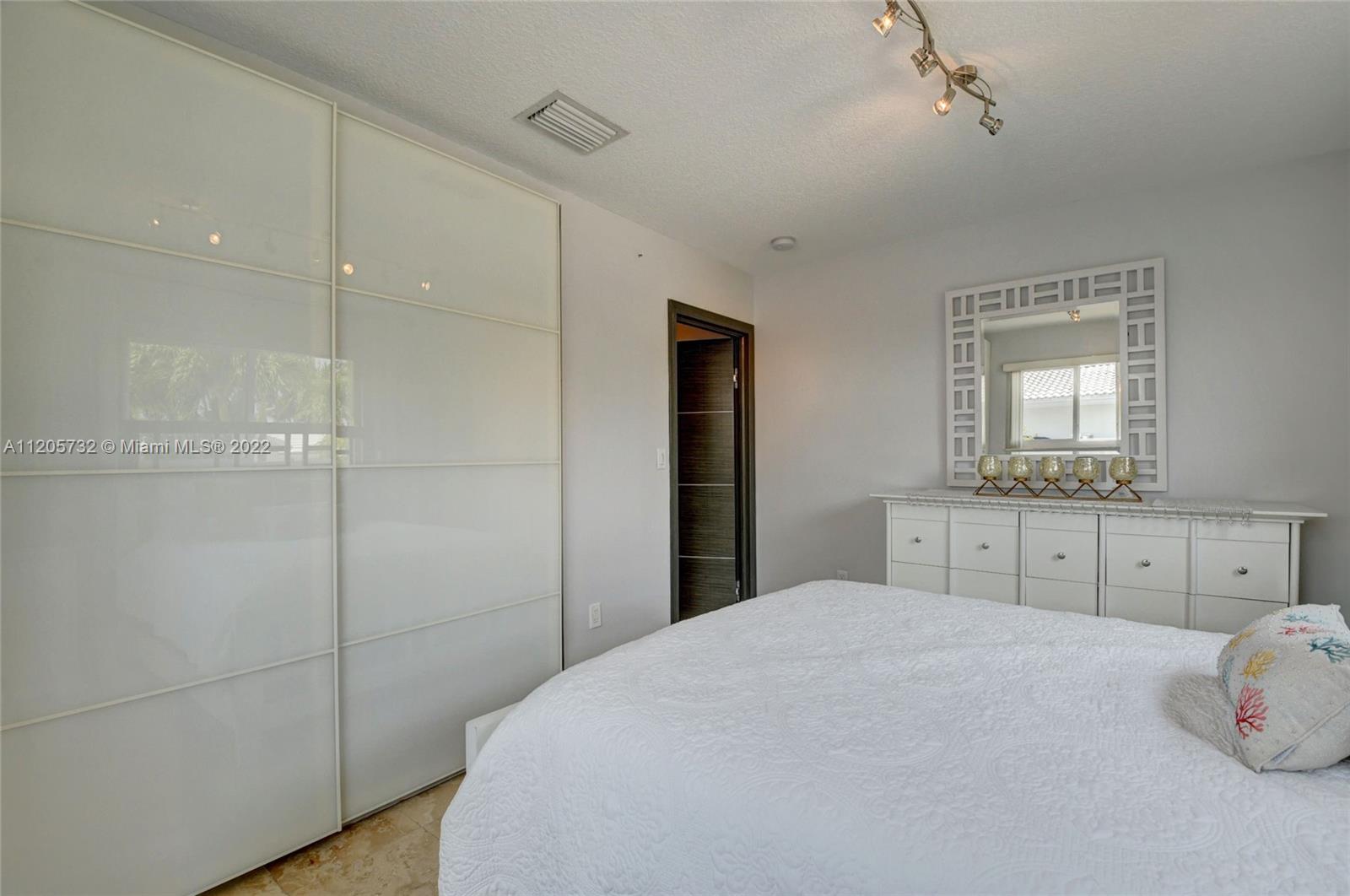 1291 Southwest 4th Court Boca Raton, FL 33432 - Photo 28 of 54 a bedroom with a bed and a mirror