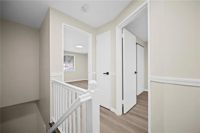 a view of a hallway with wooden floor and entryway