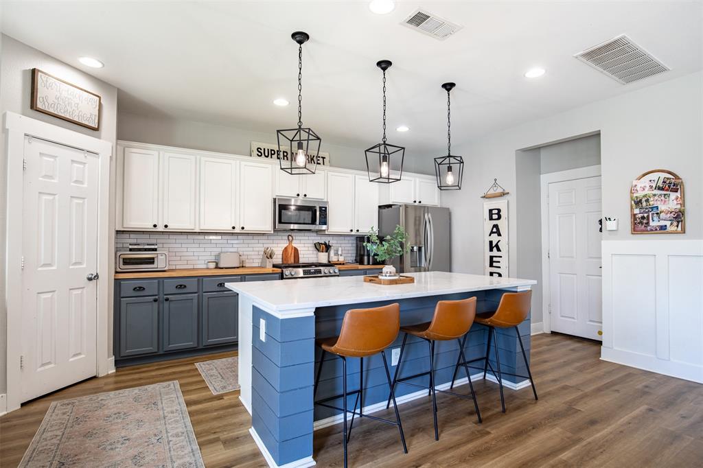 416 Allbright Road Celina, TX 75009 - Photo 10 of 40 a kitchen with stainless steel appliances a dining table chairs stove and sink