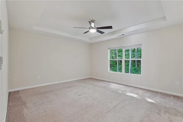 an empty room with a window and a ceiling fan