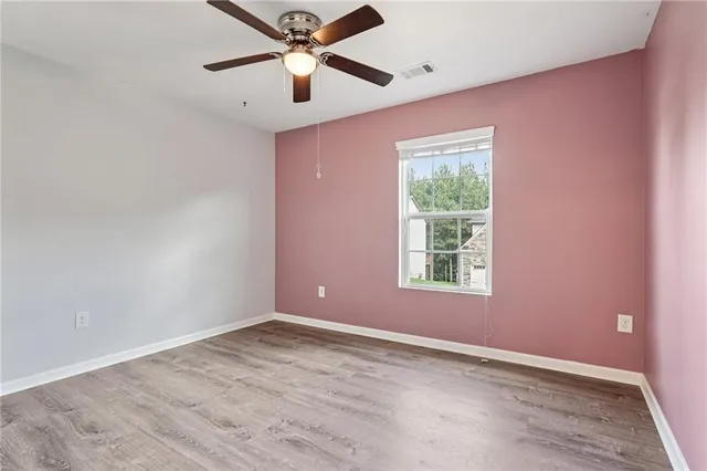 an empty room with a window and a fan