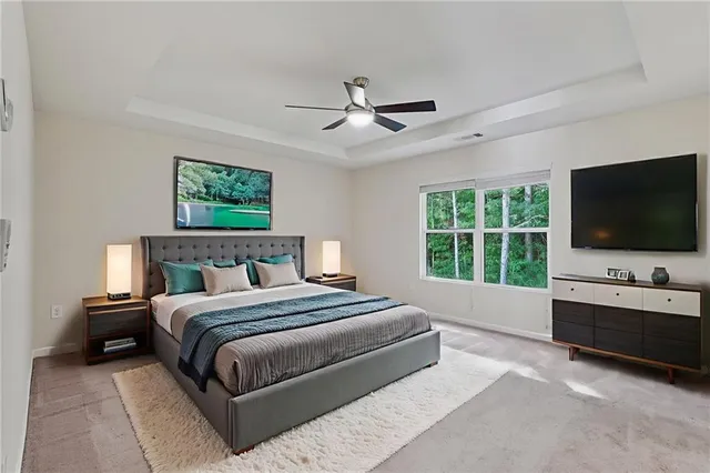a spacious bedroom with a large bed and a flat screen tv