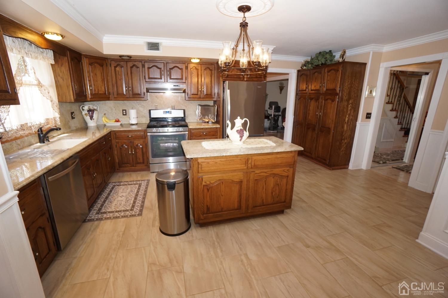 77 Inwood Avenue Colonia, NJ 07067 - Photo 12 of 37 a kitchen with stainless steel appliances granite countertop a stove a sink dishwasher a refrigerator and wooden cabinets with wooden floor