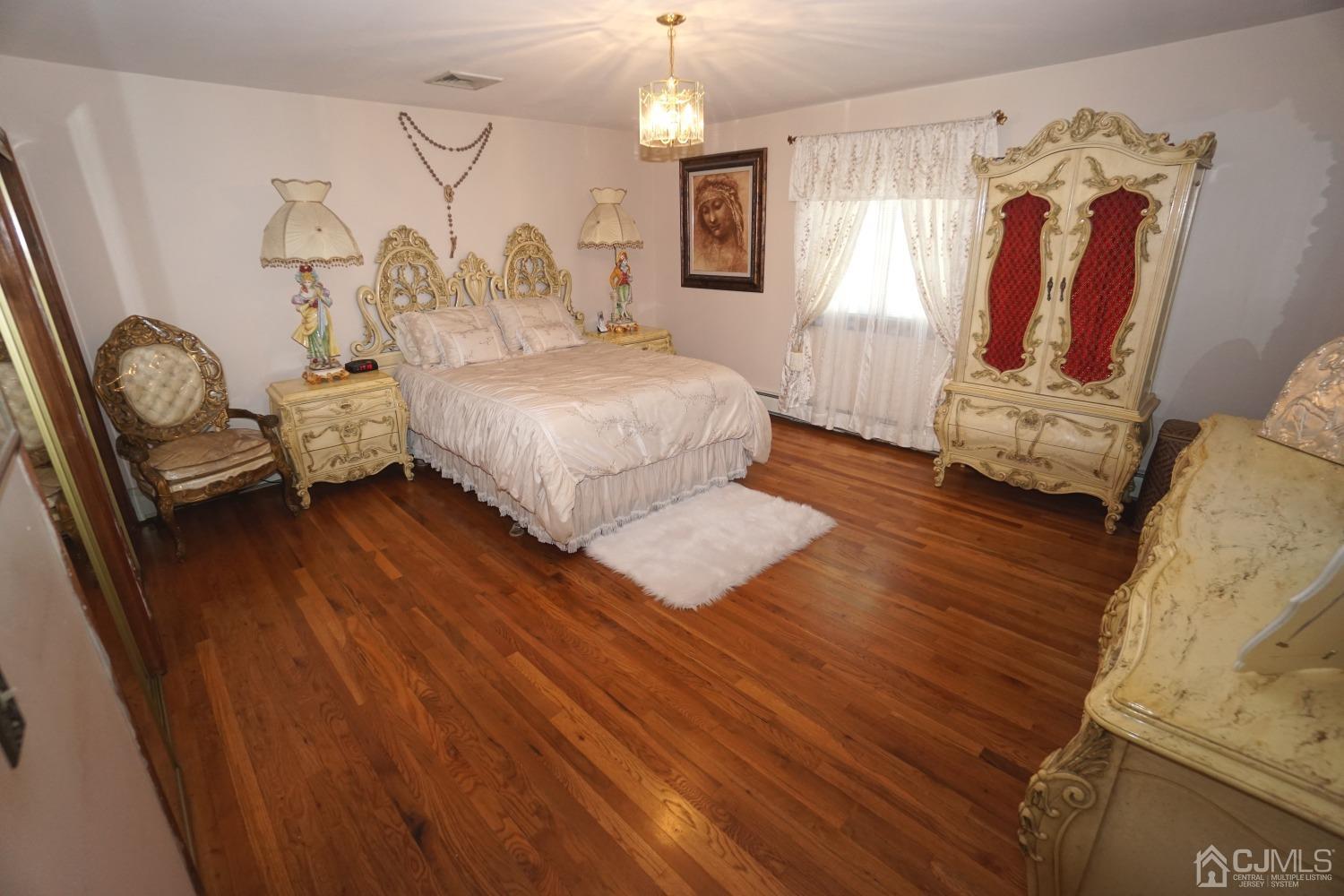 77 Inwood Avenue Colonia, NJ 07067 - Photo 14 of 37 a bedroom with a bed and a chandelier