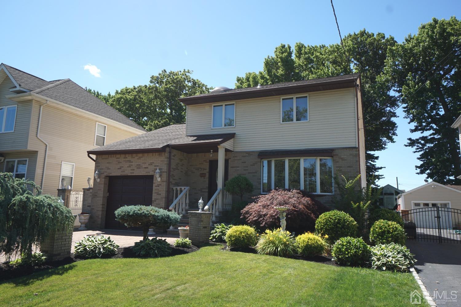 77 Inwood Avenue Colonia, NJ 07067 - Photo 2 of 37 a front view of a house with a yard and garage