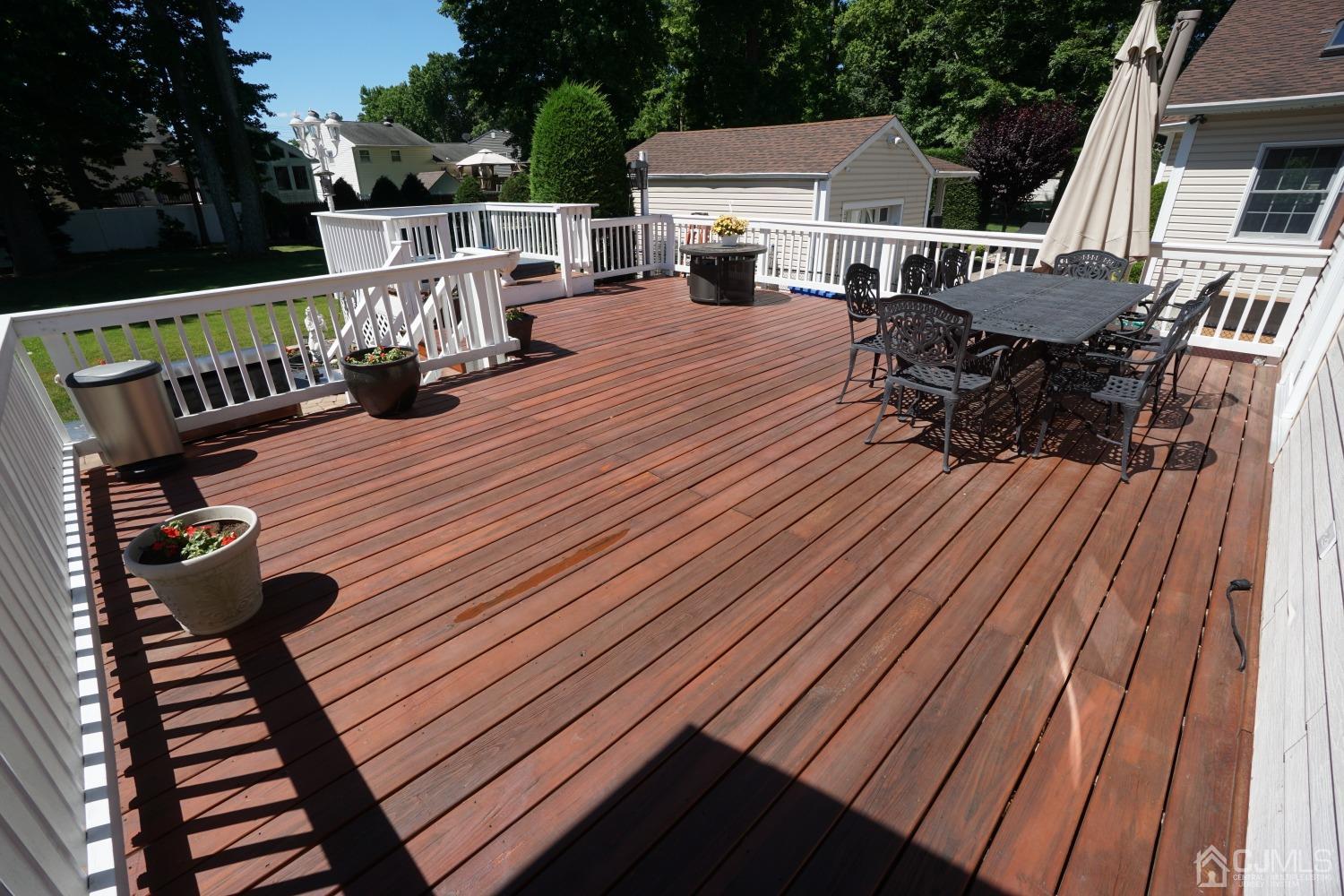 77 Inwood Avenue Colonia, NJ 07067 - Photo 28 of 37 a view of a roof deck with table and chairs a barbeque with wooden floor and fence