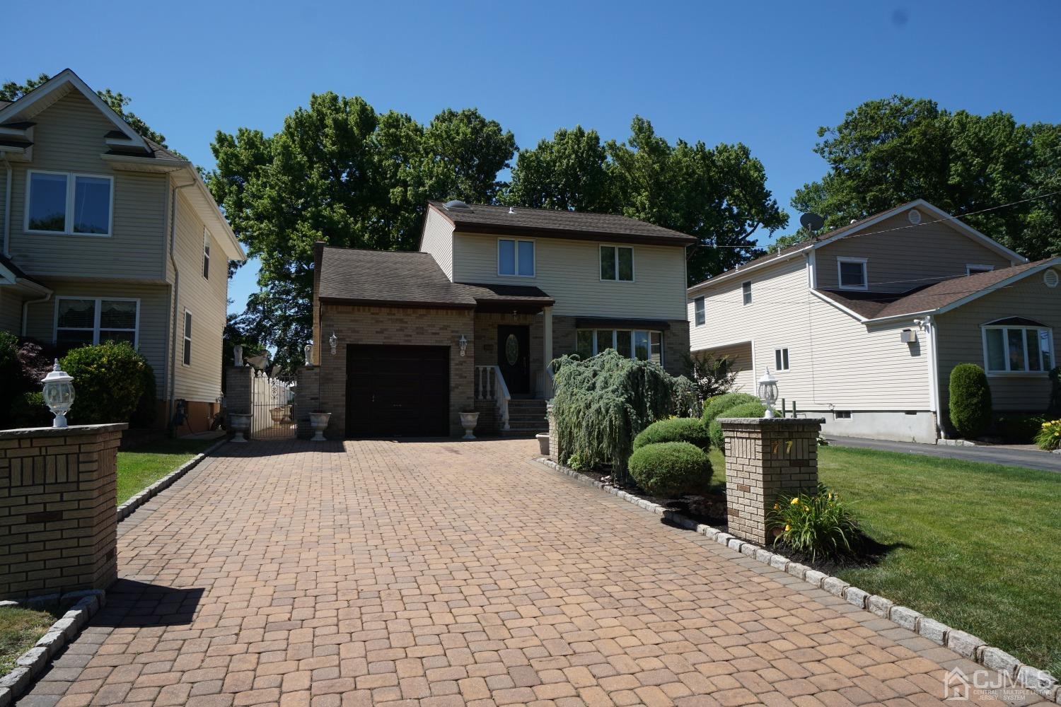 77 Inwood Avenue Colonia, NJ 07067 - Photo 34 of 37 a front view of a house with a yard and garage
