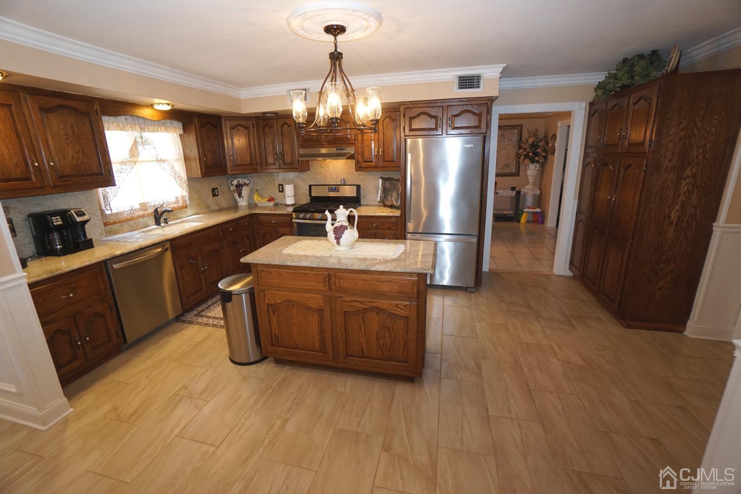 77 Inwood Avenue Colonia, NJ 07067 - Photo 7 of 37 a kitchen with stainless steel appliances a sink stove and refrigerator