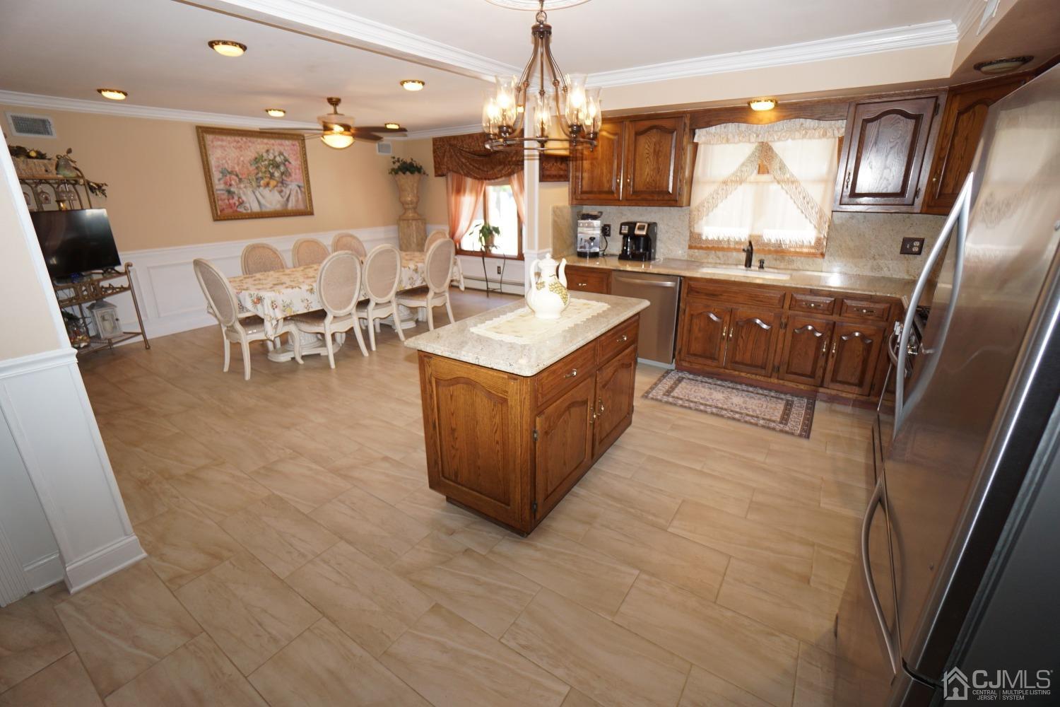 77 Inwood Avenue Colonia, NJ 07067 - Photo 10 of 37 a kitchen with stainless steel appliances granite countertop a refrigerator a sink dishwasher a dining table and chairs with wooden floor