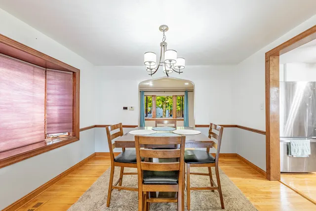 a dining room with furniture a chandelier and wooden floor