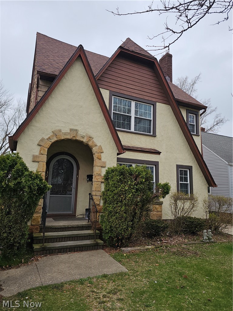 832 Hoover Road Cleveland, OH 44119 - Photo 1 of 10 English style home featuring stucco siding, a chimney, and a front yard