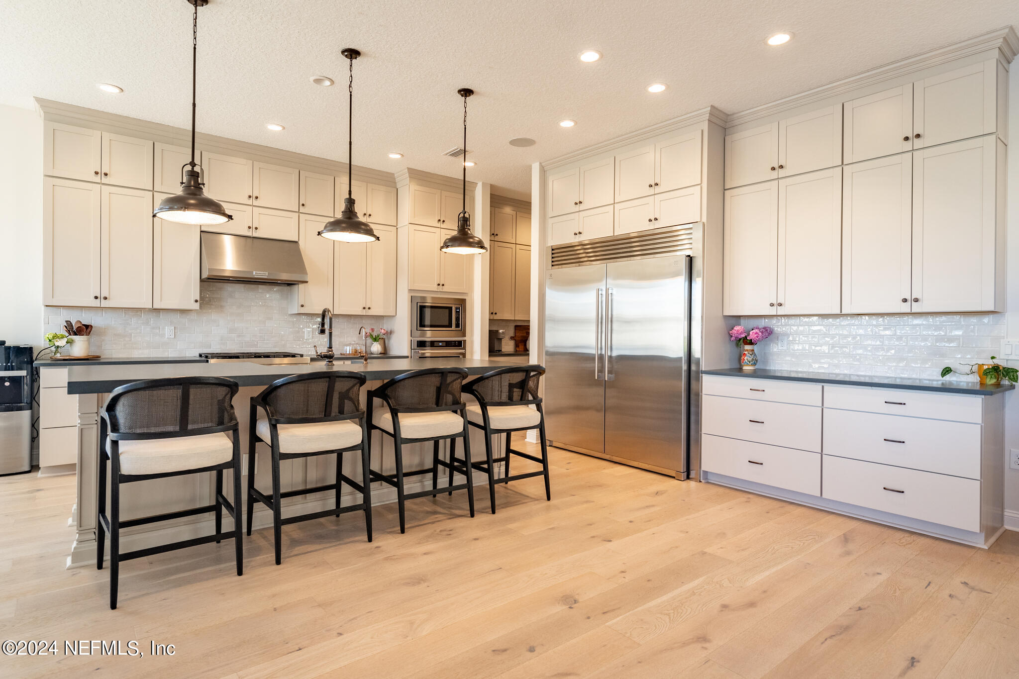 88 Awlleaf Court St. Augustine, FL 32095 - Photo 15 of 107 a kitchen with stainless steel appliances kitchen island granite countertop a table chairs sink and cabinets