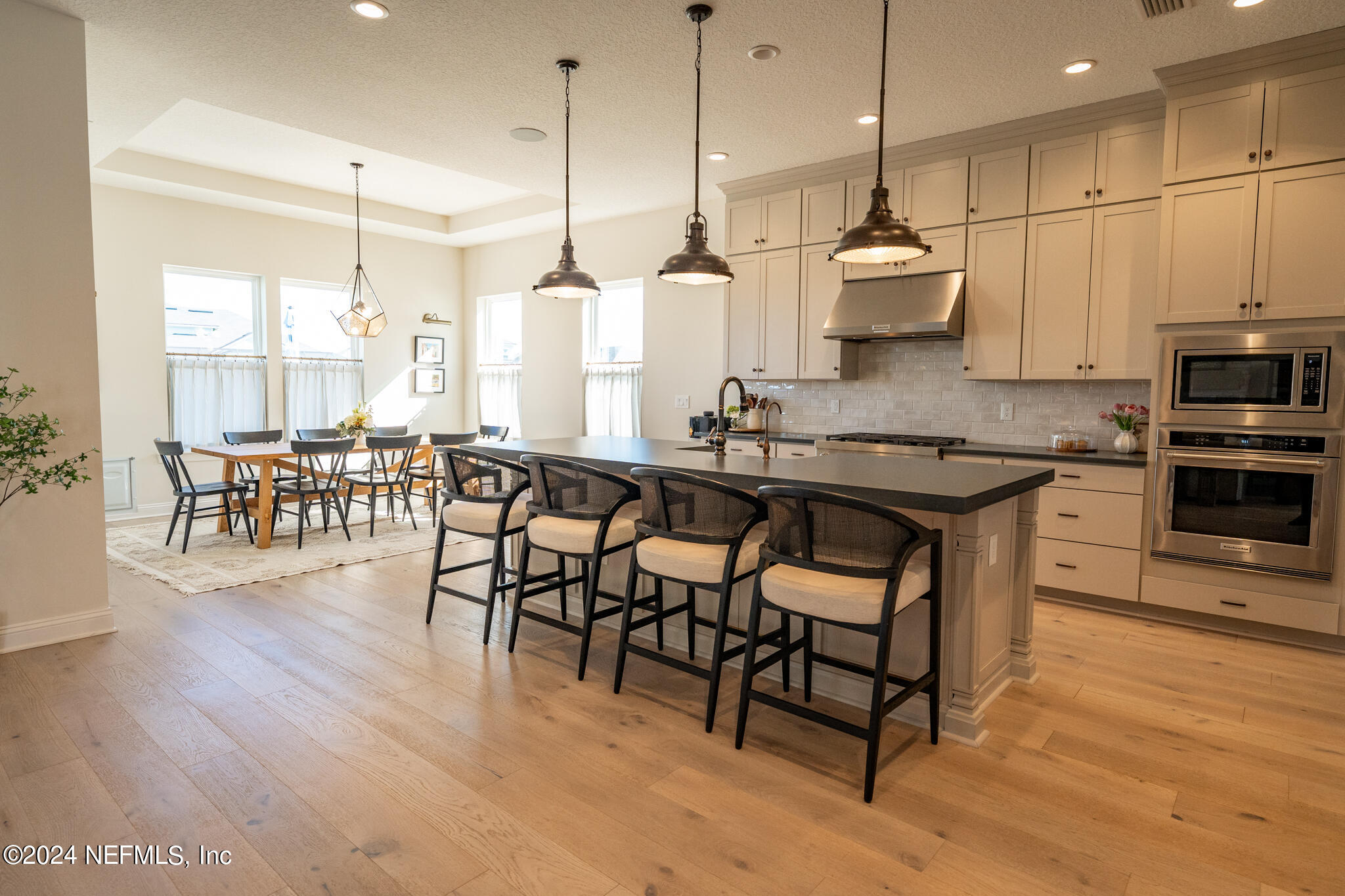 88 Awlleaf Court St. Augustine, FL 32095 - Photo 20 of 107 a kitchen with stainless steel appliances granite countertop a stove a sink a refrigerator a dining table and chairs with wooden floor