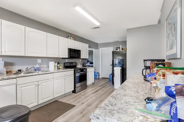 a kitchen with stainless steel appliances granite countertop a refrigerator and a stove top oven