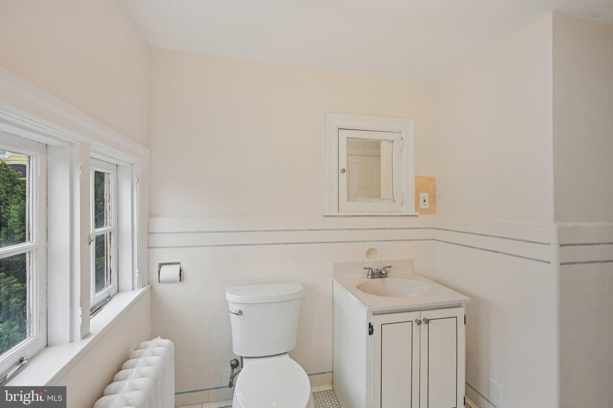908 Edge Hill Road Glenside, PA 19038 - Photo 18 of 27 a bathroom with a toilet a sink and a window