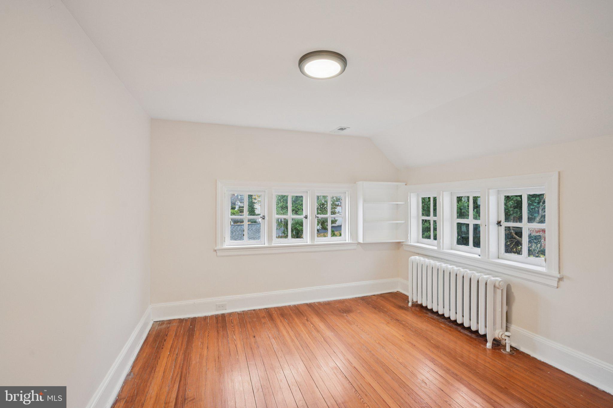 908 Edge Hill Road Glenside, PA 19038 - Photo 20 of 27 an empty room with wooden floor and windows