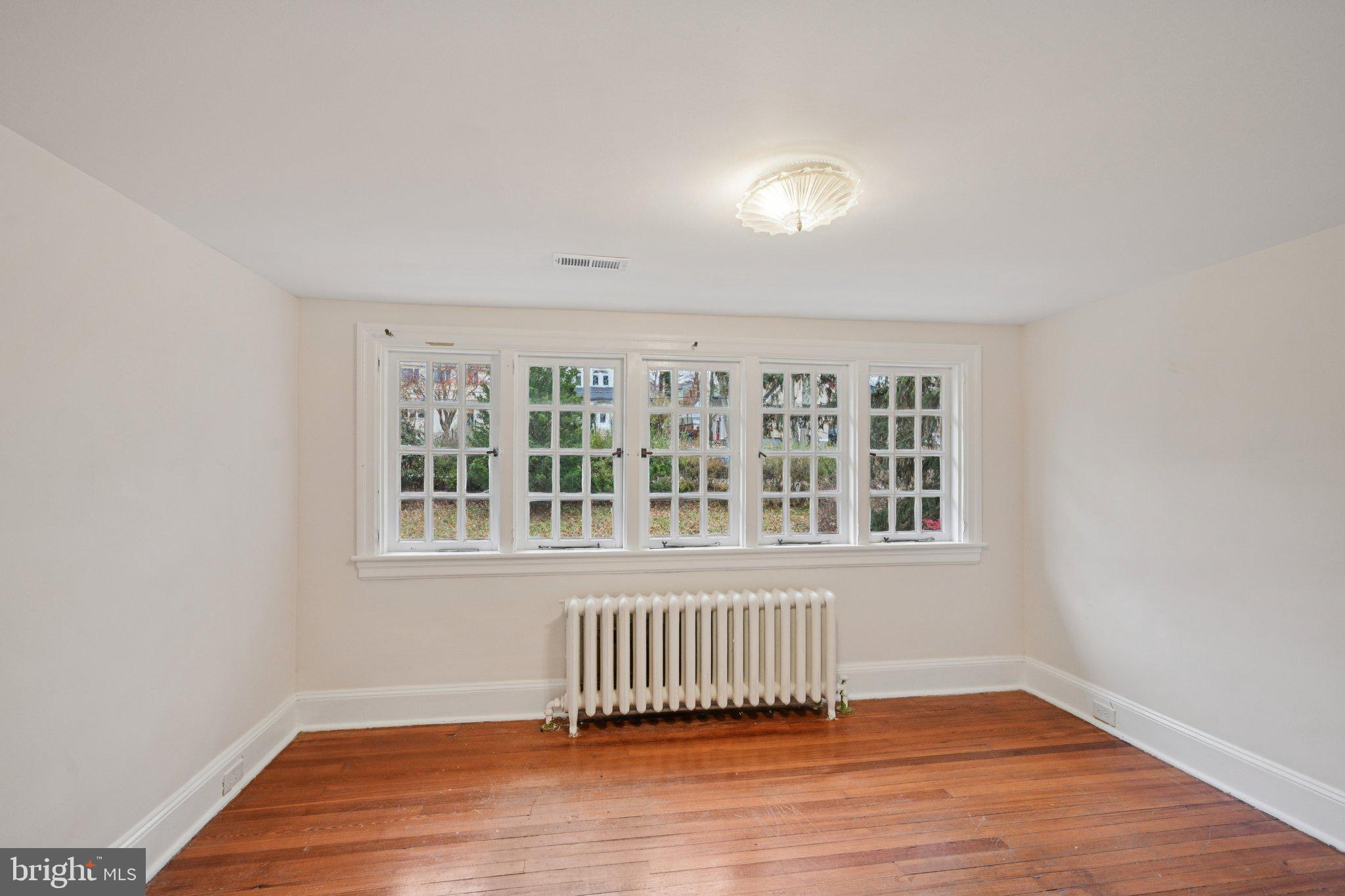 908 Edge Hill Road Glenside, PA 19038 - Photo 21 of 27 an empty room with wooden floor and windows