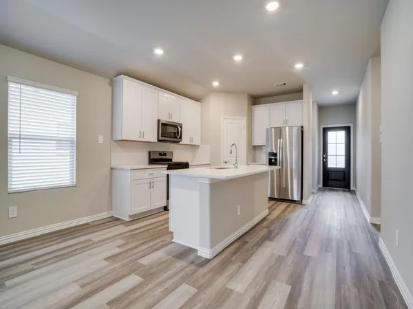 a kitchen with white cabinets and stainless steel appliances
