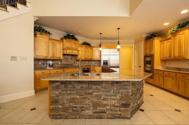 a kitchen with kitchen island granite countertop a sink and counter space