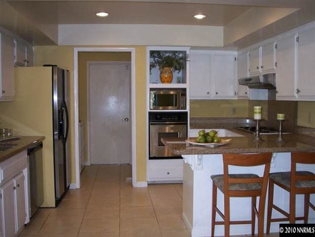 4931 Lakeridge Terrace West Reno, NV 89509 - Photo 2 of 9 a kitchen with granite countertop a refrigerator and a stove top oven