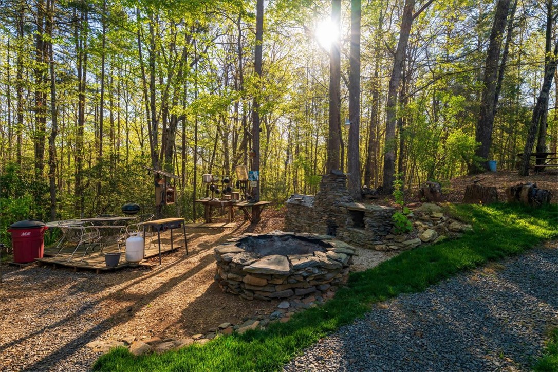 930 Nimmons Bridge Road Salem, SC 29676 - Photo 10 of 19 This serene outdoor space features a stone fire pit, ideal for cozy evenings under the trees.