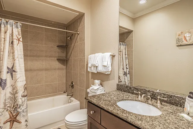 a bathroom with a granite countertop sink toilet and shower