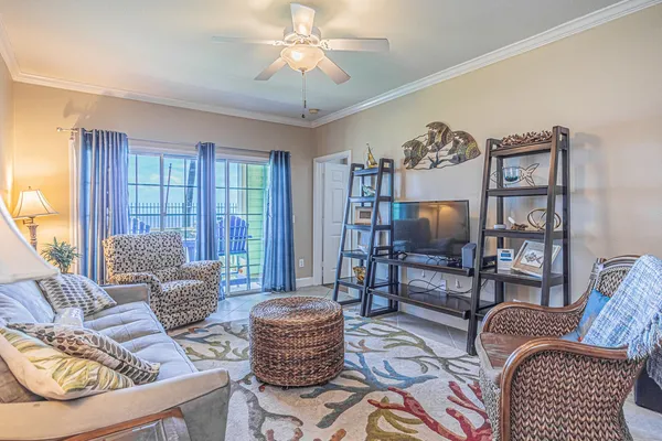 a living room with furniture a flat screen tv and a large window