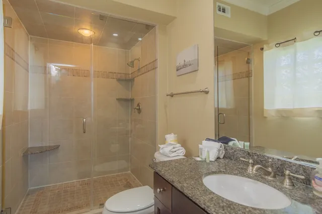 a bathroom with a granite countertop sink toilet and shower