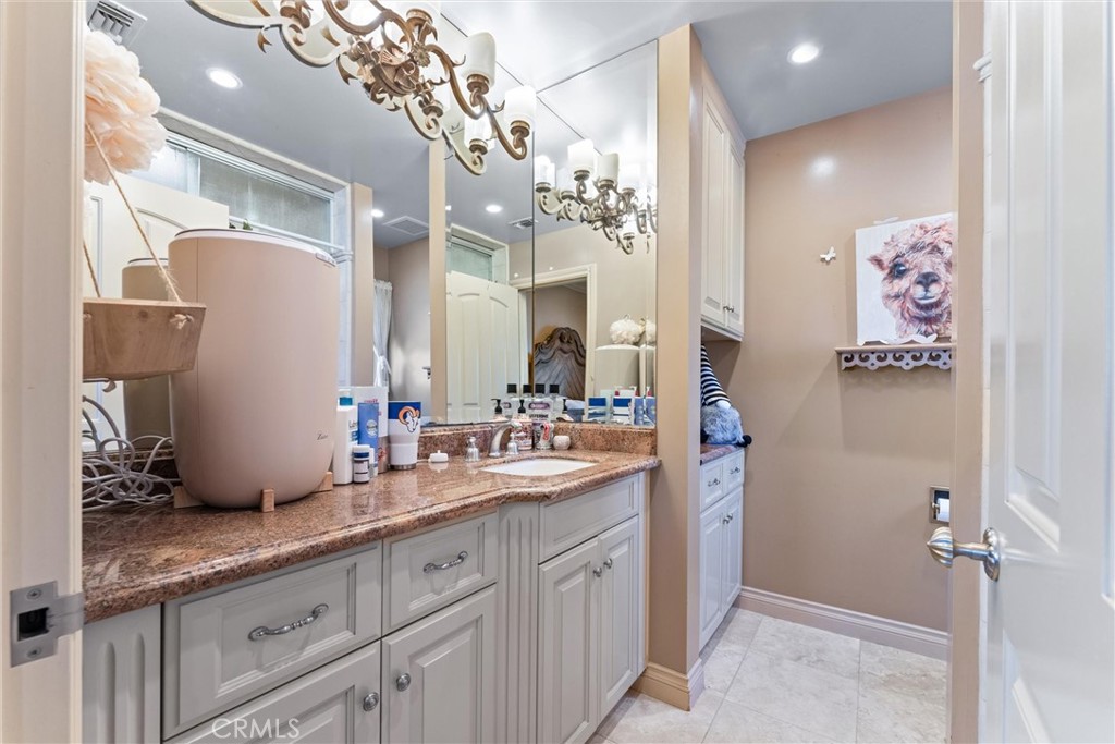3781 Ragtime Circle Huntington Beach, CA 92649 - Photo 17 of 55 a spacious bathroom with a granite countertop sink a mirror and a shower