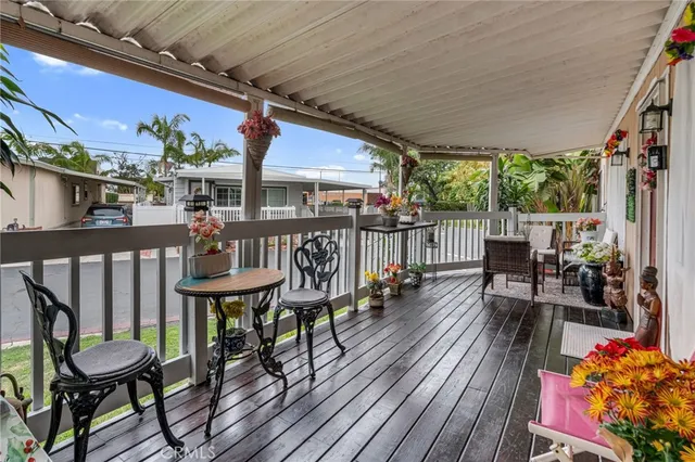 a balcony with wooden floor table and chairs
