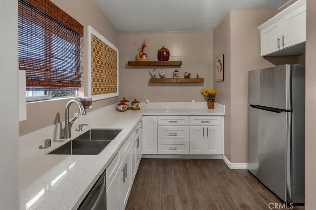 a kitchen with a sink dishwasher a refrigerator and cabinets