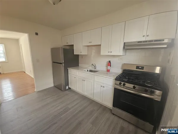 a kitchen with cabinets appliances and wooden floor