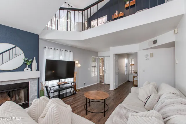 a living room with furniture a flat screen tv and a fireplace