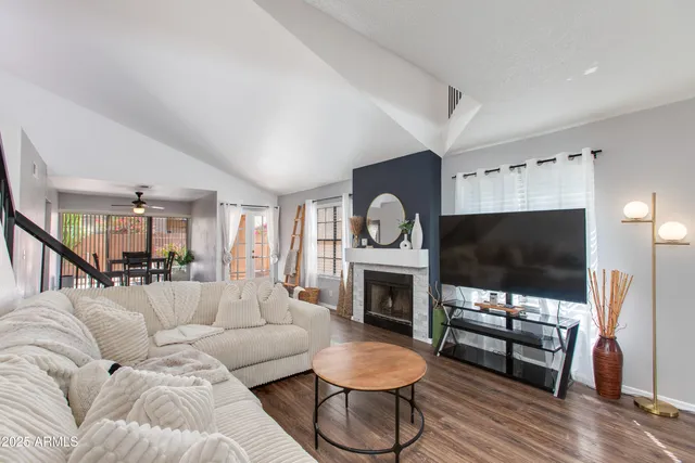 a living room with furniture a flat screen tv and a fireplace