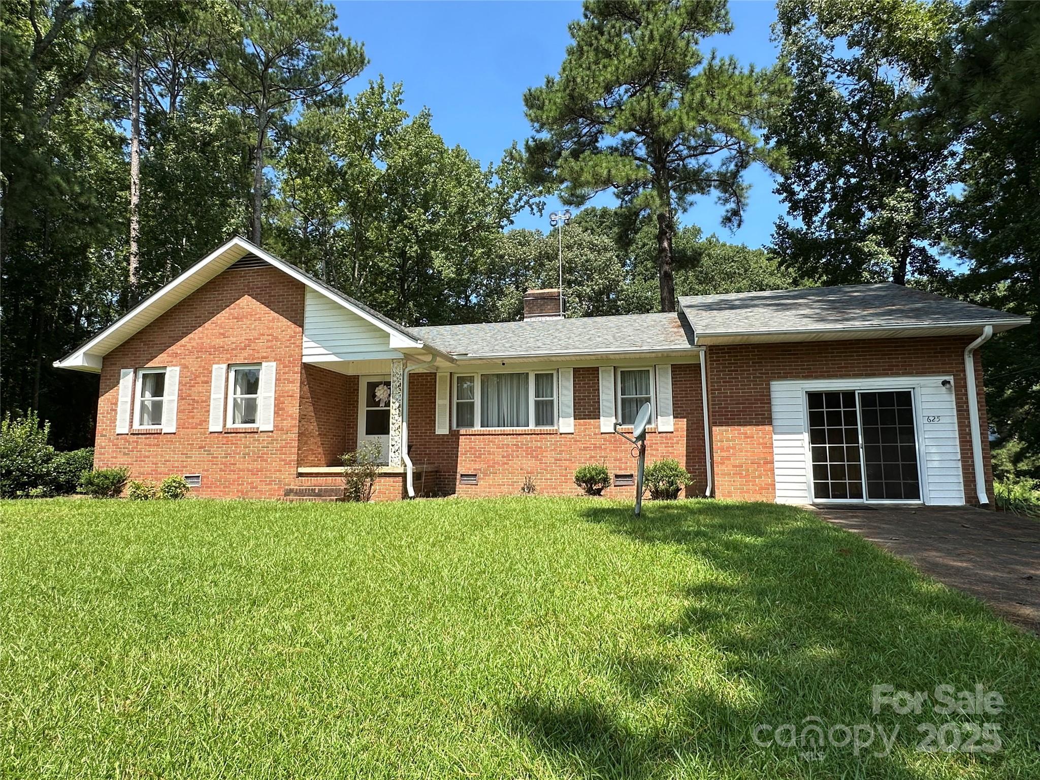 a front view of a house with a yard and trees