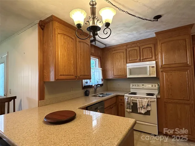 a kitchen with stainless steel appliances granite countertop a sink a stove and a refrigerator