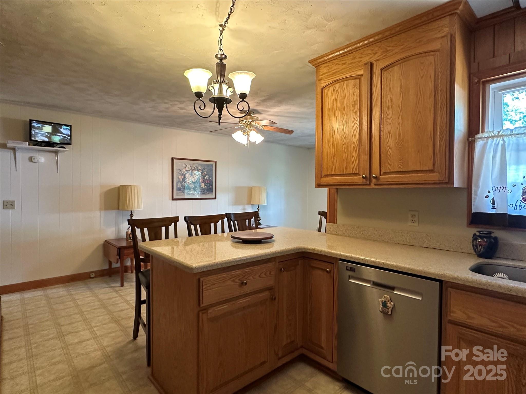 625 Teddar Road Mount Gilead, NC 27306 - Photo 12 of 25 a kitchen with stainless steel appliances granite countertop a sink dishwasher a stove and a dining table with wooden cabinet