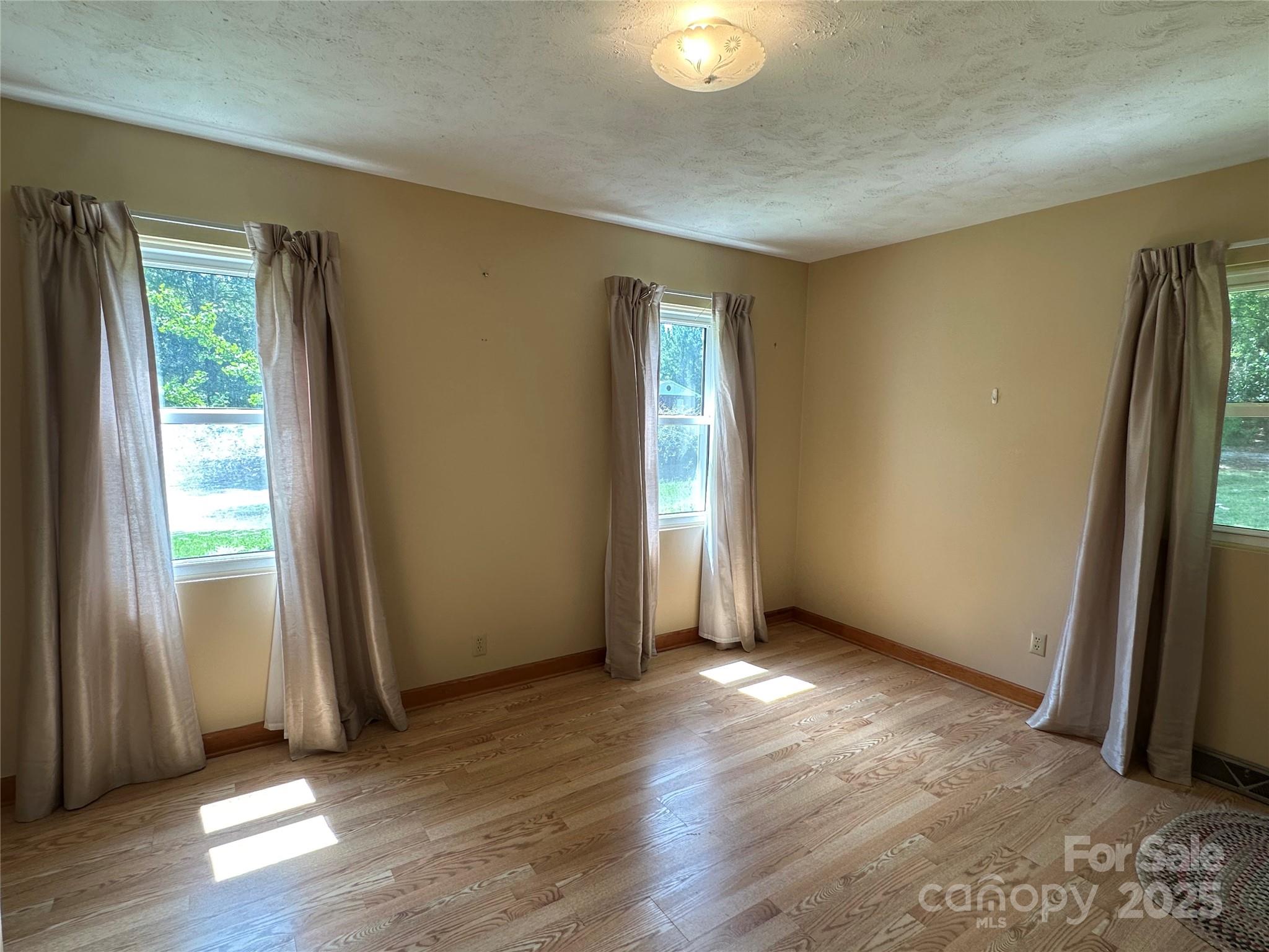 625 Teddar Road Mount Gilead, NC 27306 - Photo 18 of 25 an empty room with wooden floor and windows