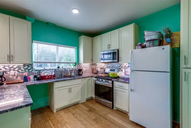 a kitchen with a sink cabinets and wooden floor