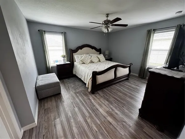 a bedroom with a bed wooden floor and window